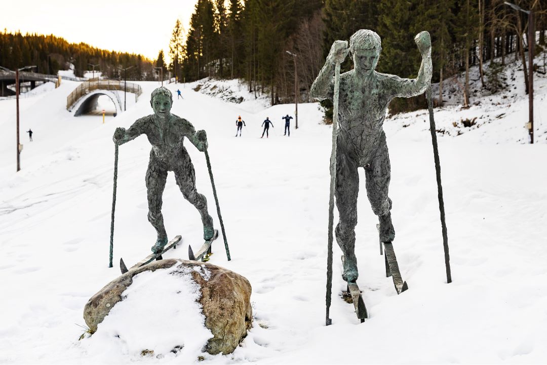 To statuer av barn som g&aring;r p&aring; ski, med skil&oslash;yper i bakgrunnen