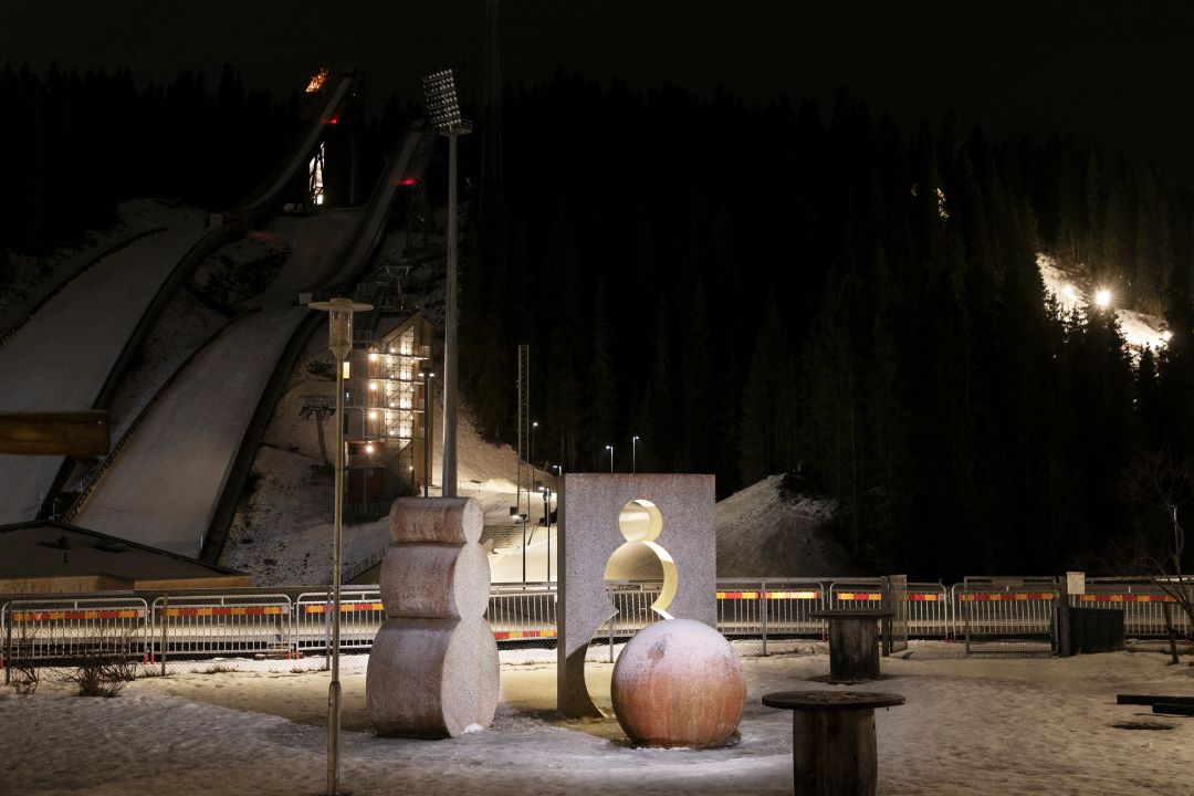 Steinfigurer som ser ut som sn&oslash;menn foran hoppbakke