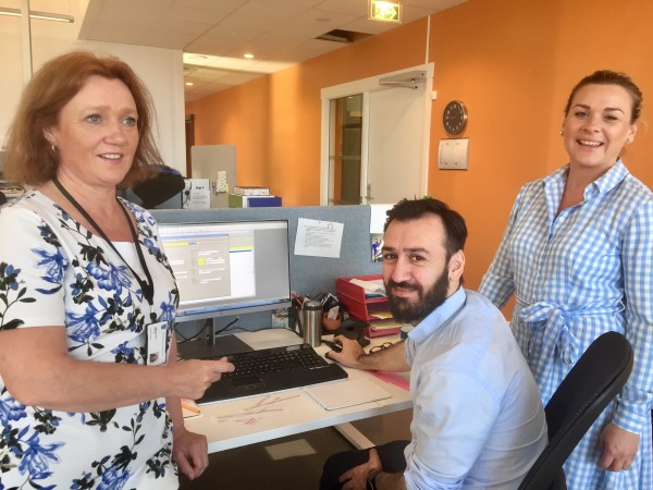 Murtaza Mastoor, Hege &Oslash;straat og Tone Selb&aelig;k st&aring;r ved en kontorpult