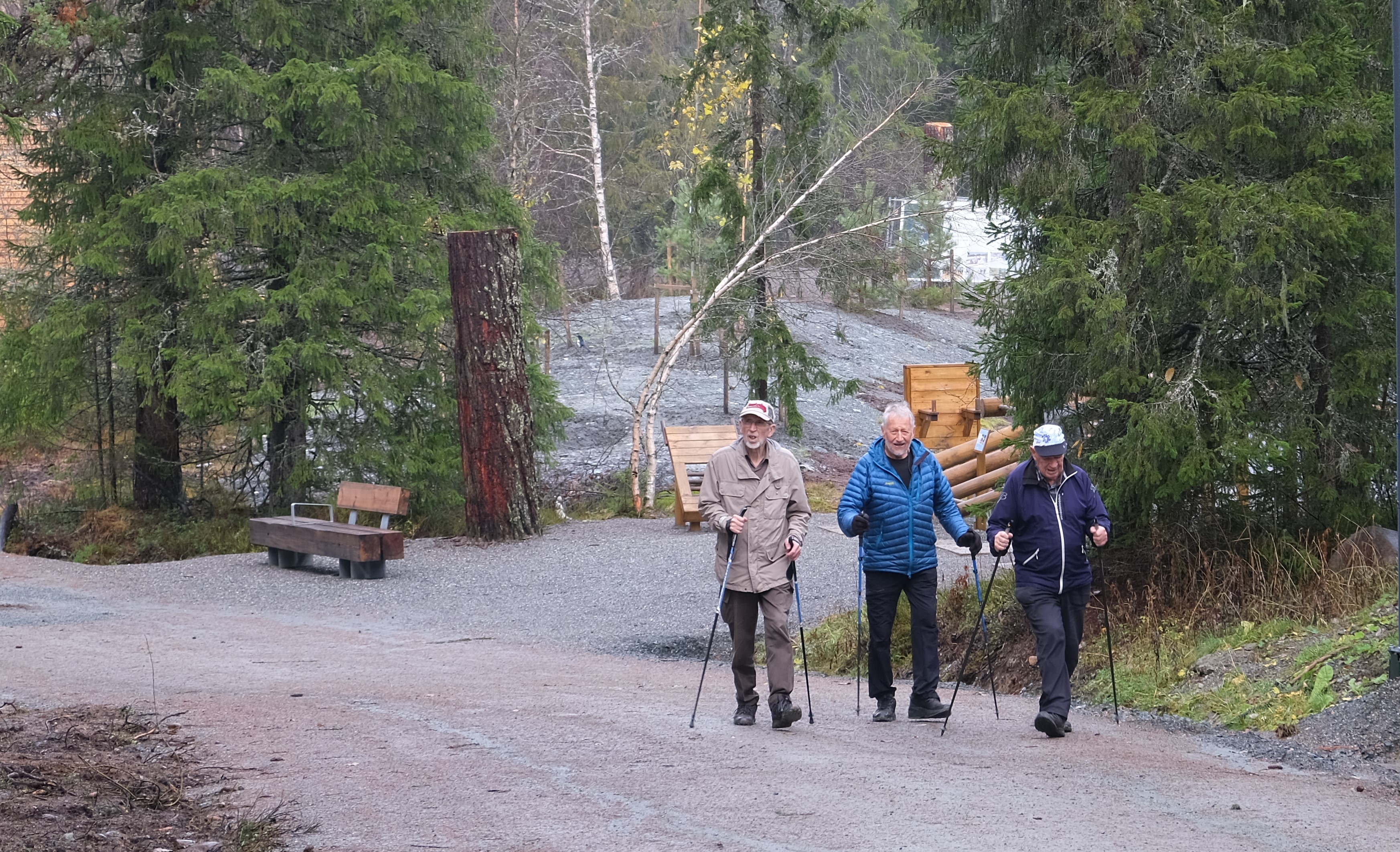 Tre menn går på en grusveg
