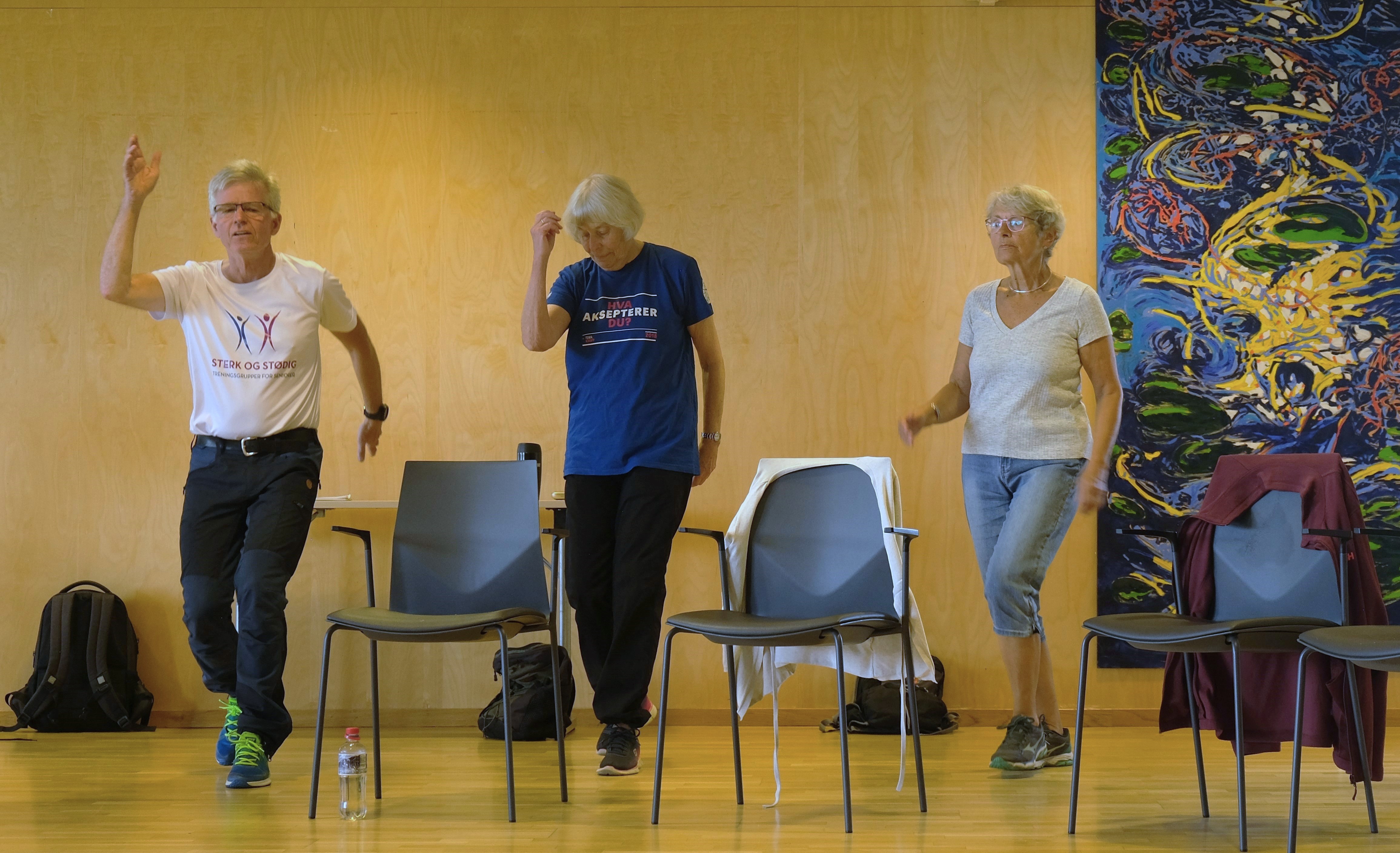 Tre personer som gj&oslash;r trenings&oslash;velser ved stol