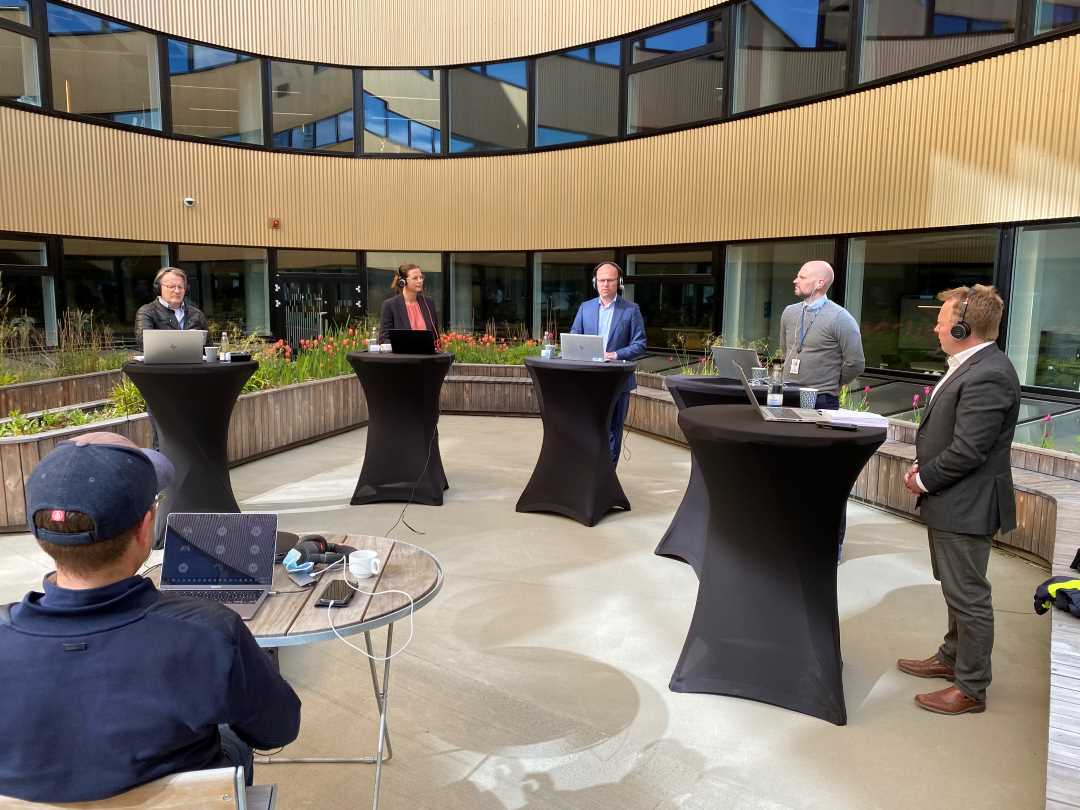 Bilde av foredragsholderne bak hvert sitt ståbord i atriet på Powerhouse