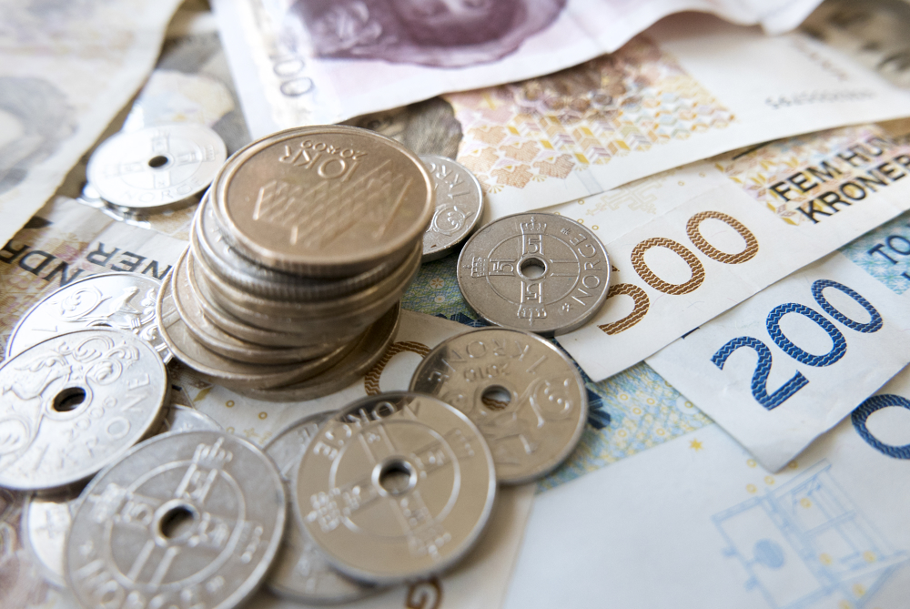 Bildet viser en stabel med nyter og sedler.