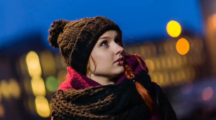 Bilde av ansikt til kvinne som ser bortover en bygate.