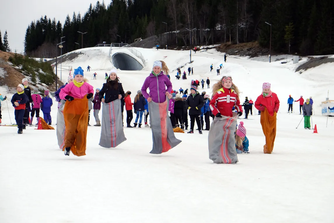 Barn som hopper om kapp i snøen