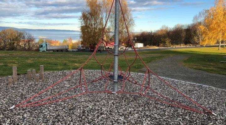 Et klatrestativ med gressplen i bakgrunnen