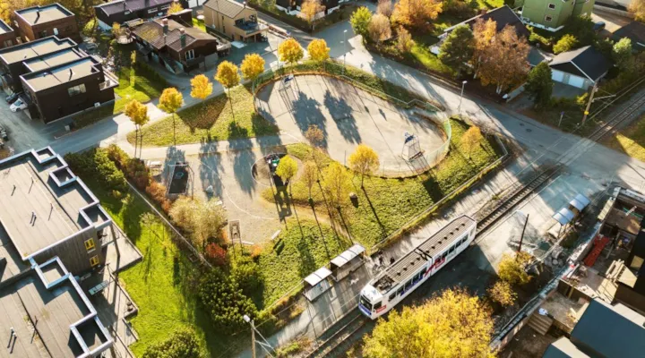Oversiktsbilde over lekepark med trikk som står ved trikkeholdeplass