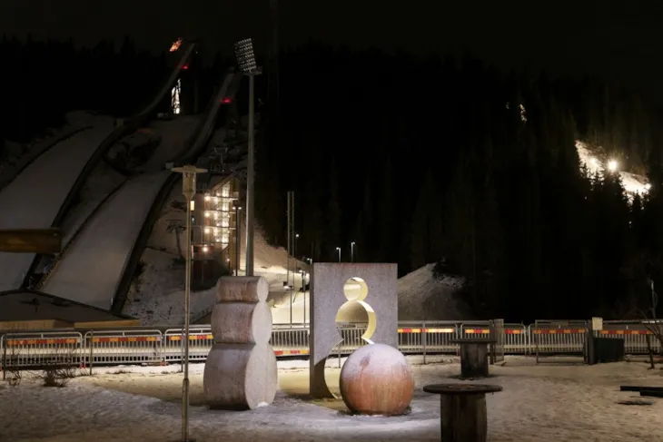 Steinfigurer som ser ut som snømenn foran hoppbakke