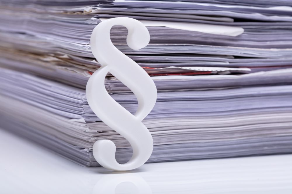 En bunke med papirer med et paragraftegn foran