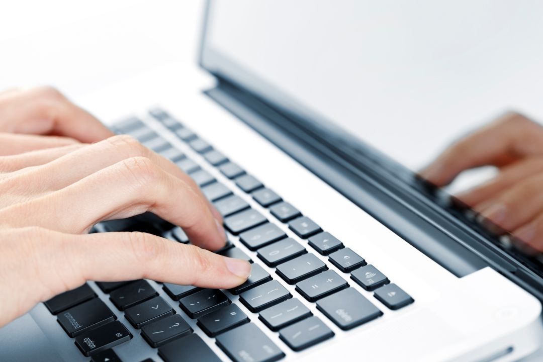 Fingre som taster på en bærbar pc