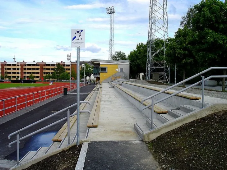 Tribuneanlegget på Øya stadion er tilgjengelig for rullestolbrukere, er utstyrt med teleslynge (skiltet hvor) og har håndløpere i 2 høyder langs trappa