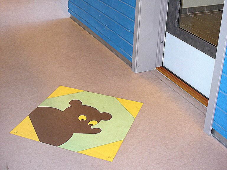 Med klare farger, kontraster og og en enkel figur på gulvet blir det tydelig hvor døra er