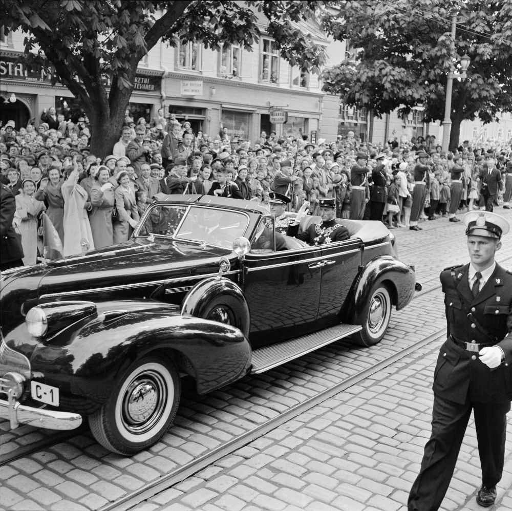 Kong Olav og kronprins Harald i sin Buick under signingen i Trondheim i 1958.