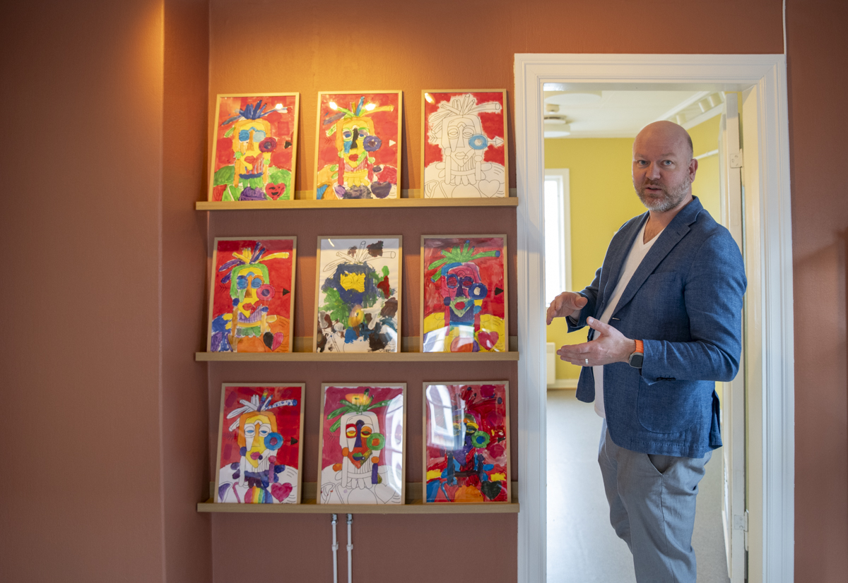 Rektor står ved siden av ni utstilte verk, inspirert av picasso.