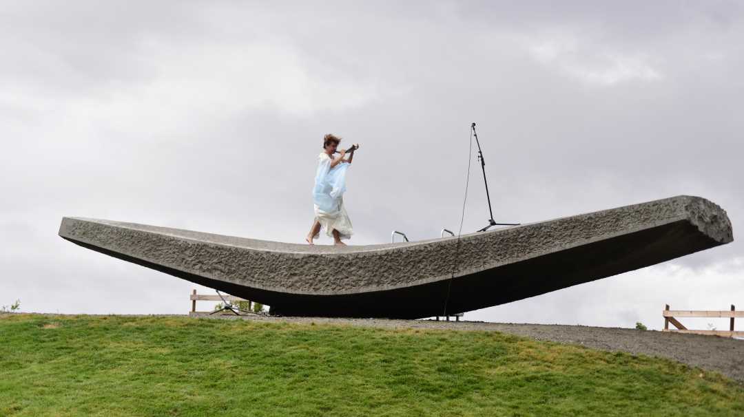 Bilde av musiker som blåser i horn på skulpturen Flyvende flytende